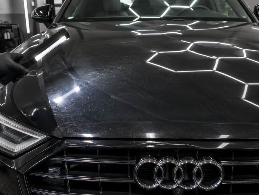 Voorbeeld: motorkap van een zwarte Audi met swirls onder de inspectielamp
